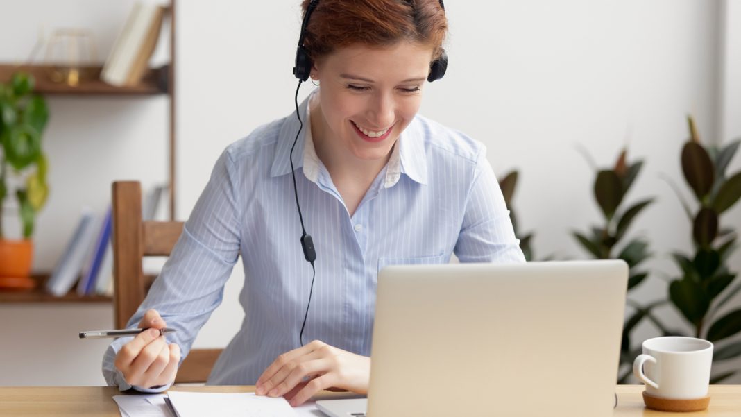 Woman in headphones self-study at office desk immagine